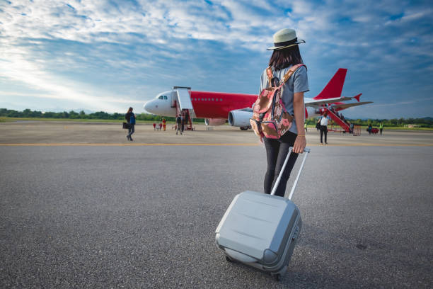 Girl traveler with luggage going to plane for travel